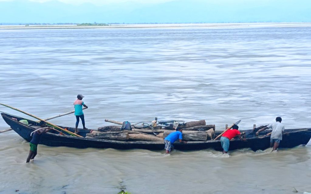 सप्तकोशीमा डुंगा चढेर दाउरा खोज्दै (फोटो)